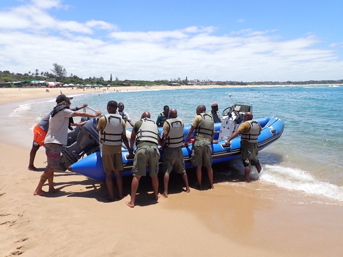 Image of group pushing boat on beach during MPA training in Mozambique