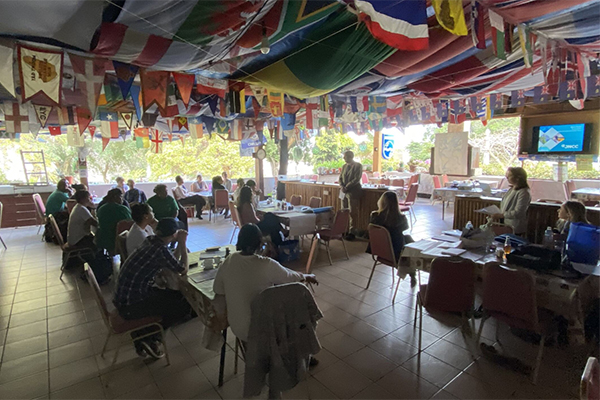 Photograph of participants at the workshop in St Helena. Participants are seated around tables and looking towards a presenter at the front of the room